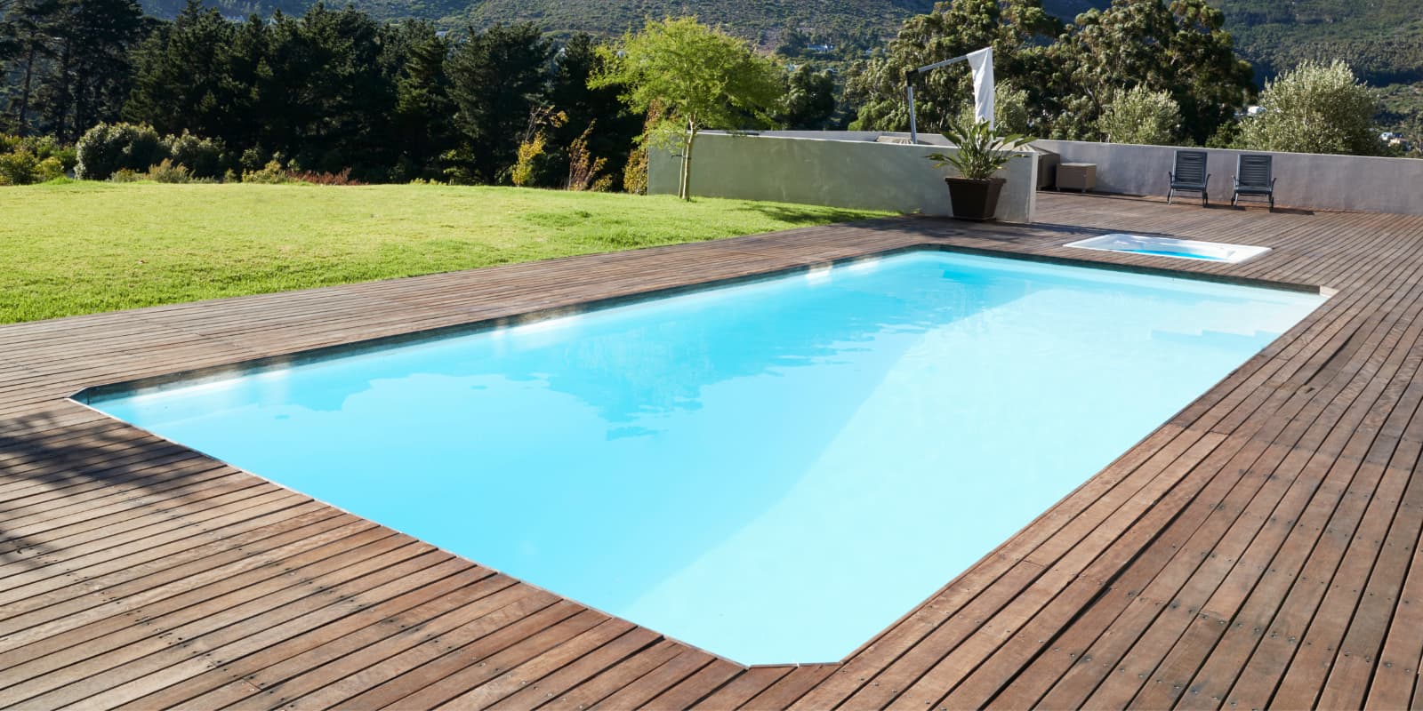 Grande piscine coque avec plage en bois