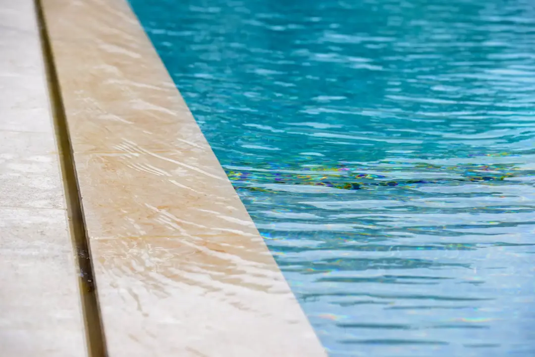 Le principe d’une piscine à bord miroir Diffazur avec zoom sur la margelle immergée