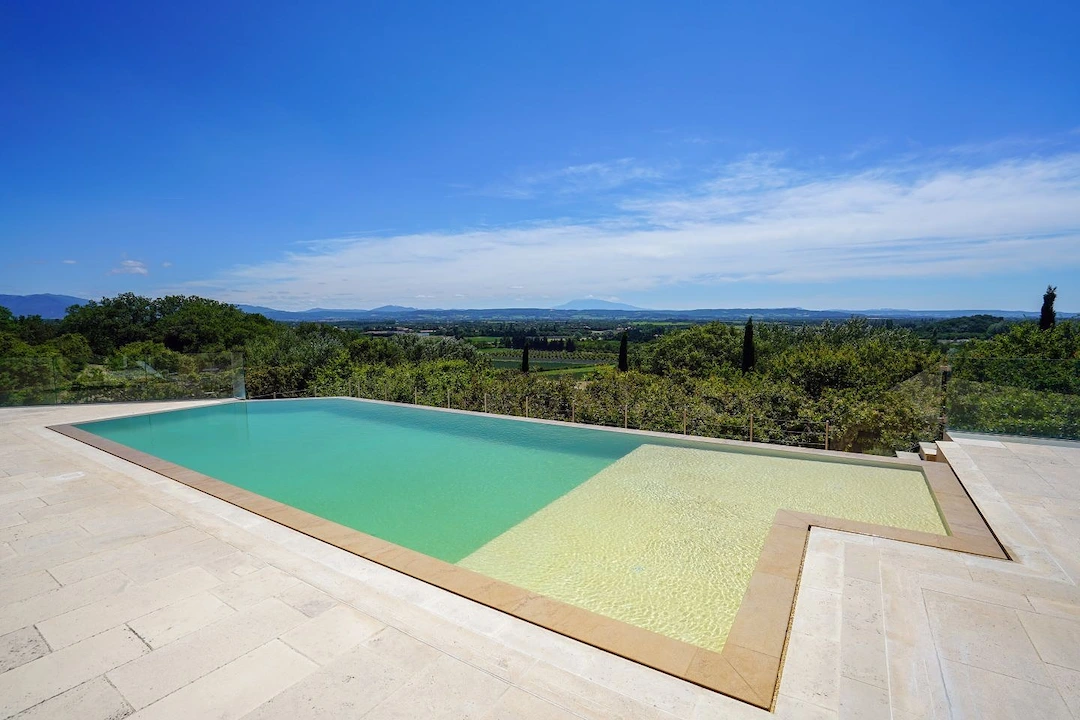 Piscine moderne à débordement avec revêtement sable