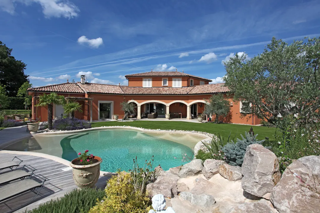 Piscine lagon creusée avec rocher décoratif à Lyon